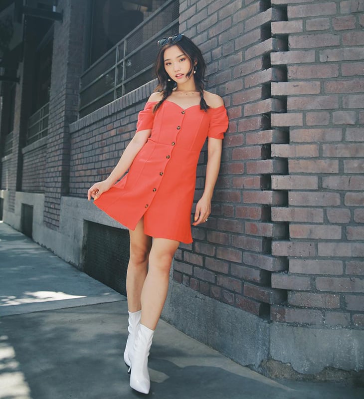 Trong cách phối khác, Jenn Im chọn loại đầm ngắn hở vai màu san hô và giày boots trắng mũi nhọn 