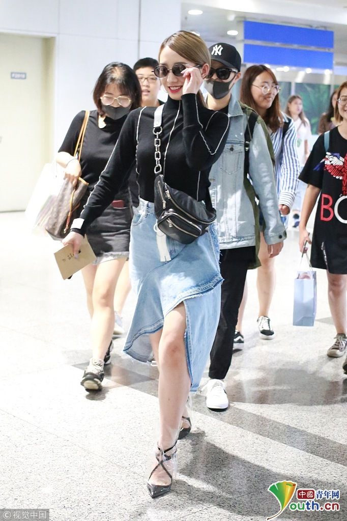 Mạnh Mỹ Kỳ khoe chân thon với chân váy denim bất đối xứng của Chanel phối cùng túi đeo chéo ngang ngực, giày cao gót dạng bốt trong suốt.