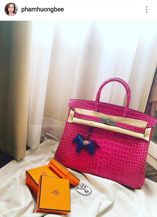 Phạm Hương háo hức đón chiếc túi Hermes Birkin 35 chất liệu da cá sấu màu hồng sen có giá khoảng 1,4 tỷ đồng về tay sau bao ngày đợi mong. Item đã giúp Phạm Hương soán ngôi vô địch trong cuộc đua túi hiệu tháng 7.    
