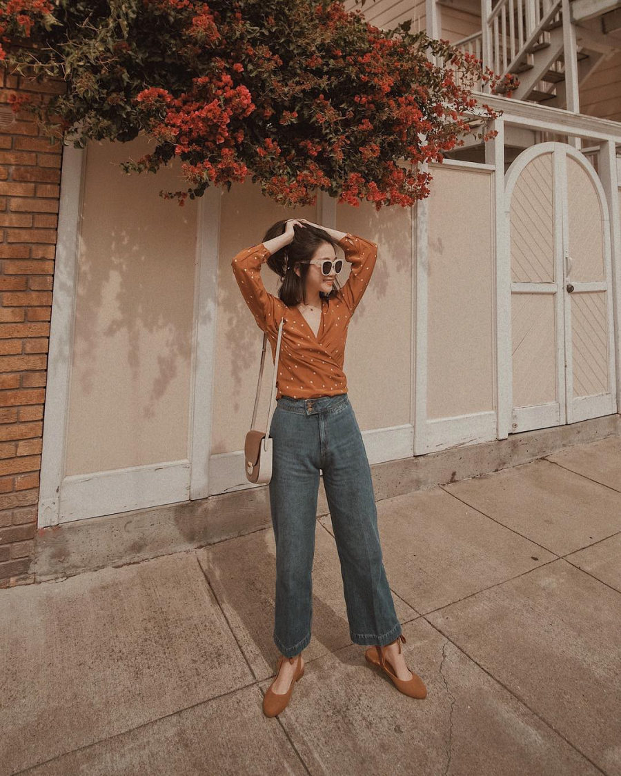 Cá tính như quần jeans ống rộng cũng có thể diện đến công sở nếu bạn chọn một thiết kế áo blouse nhẹ nhàng để diện cùng. Set đồ sẽ ghi điểm hơn cả khi bạn chọn thêm một đôi giày slingback xuyệt tông cùng áo.    