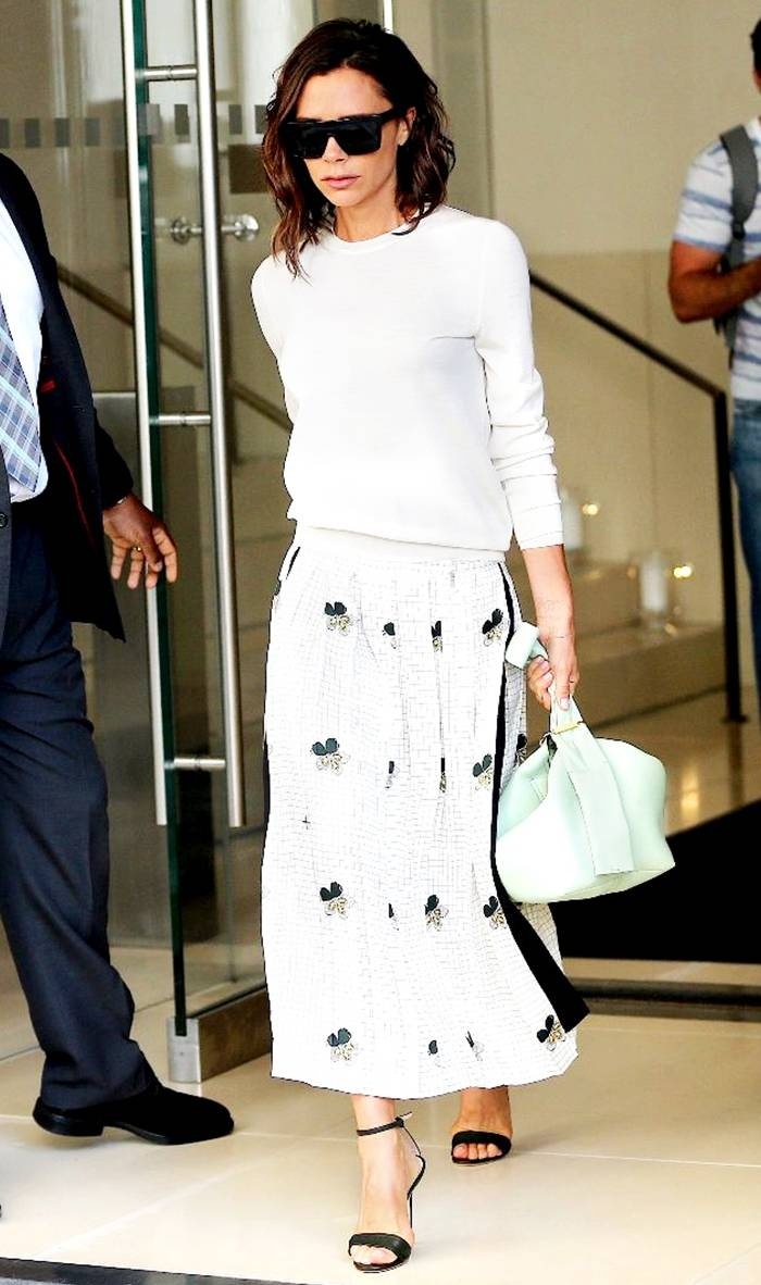 Áo len trắng và chân váy midi in hoa cùng túi xách, kính mắt, dép quai ngang giúp bà xã David Beckham trẻ trung, tươi tắn khi xuống phố.     
