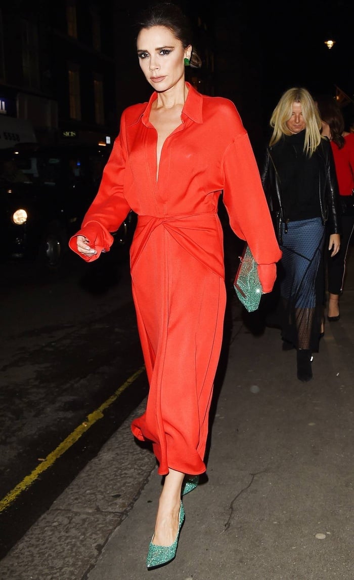 Victoria Beckham trông thanh lịch chứ không hề loè loẹt khi diện váy màu đỏ cùng túi xách và giày màu xanh ngọc bích.     