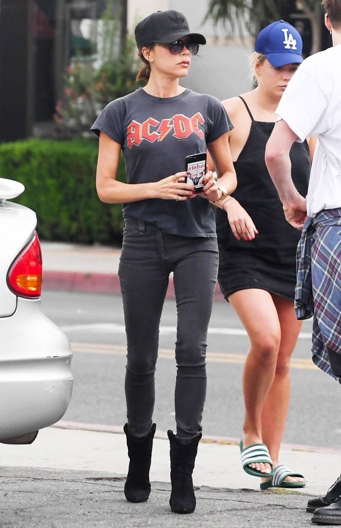 Xuất hiện trên phố, bà xã David Beckham diện áo thun màu xám cùng quần skinny, giày boots đen và mũ bóng chày tối màu.     