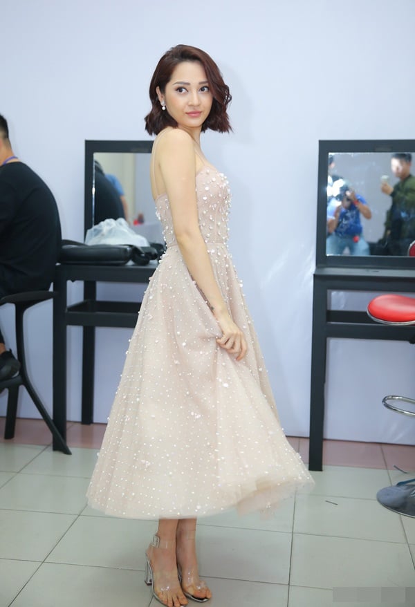 Trong buổi ghi hình vòng Giấu mặt The Voice Kids 2018, Bảo Anh biến hóa thành công chúa xinh xắn trong chiếc đầm hai dây đính ngọc trai. Nữ ca sĩ khéo léo kết hợp cùng sandal cao gót trong suốt giúp tôn dáng.    