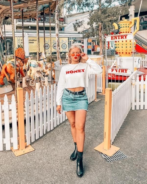Shania Kufner bắt cặp áo crop top dài tay cùng chân váy jean và bốt da tạo nên style cá tính mà khỏe khoắn bất ngờ.    
