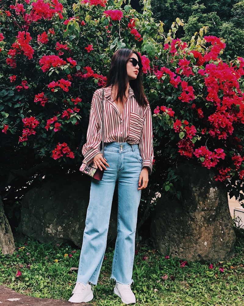Biến tấu ngẫu hứng phong cách công sở với quần denim ống rộng và sơ mi, Diễm My 9X thay vì mang giày cao gót lại chọn sneakers để tôn lên phong cách năng động, phóng khoáng.    