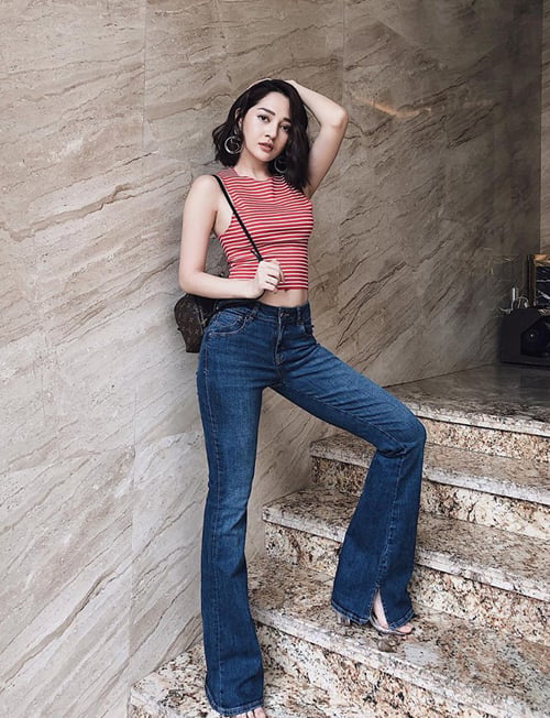 Không hẹn mà gặp, Bảo Anh cũng khoe eo thon, dáng chuẩn bằng tank top hở rốn và quần jeans ống loe cạp trễ.    