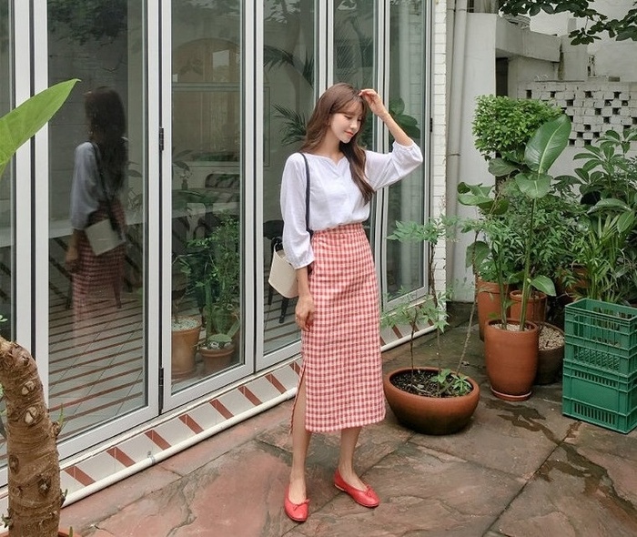 Chân váy midi cạp cao kẻ caro vừa giúp chị em ăn gian chiều cao vừa tạo cảm giác eo thon gọn. Bạn có thể phối áo phông trơn, thêm một vài món đồ phụ kiện như túi xách, giày dép,…    