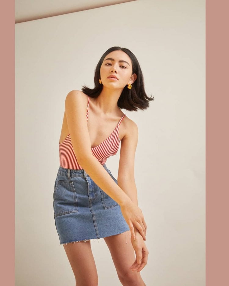 Sành điệu, thời thượng khi cô nàng mix&match chân váy jean với áo 2 dây, nhấn nhá bằng 1 đôi bông tai hoa nổi bật.  