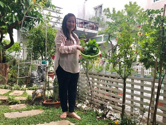 Nghệ sĩ Hồng Vân tươi rói bên rổ rau vừa hái trong vườn.    