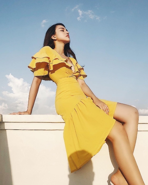 Tông màu vàng mù tạt trendy dường như vẫn chưa có dấu hiệu hạ nhiệt sau khi 'làm mưa làm gió' suốt cả một mùa hè vừa qua. Yumi Thiên Nga lựa chọn gam màu rực rỡ này cho phong cách của mình bằng cách chưng diện một mẫu đầm cổ V nhún bèo khá điệu đà và gợi cảm.    