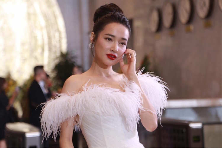 Nhã Phương dù bận rộn chuẩn bị cho Quatrian shbet hiện đang mở với bạn trai Trường Giang nhưng vẫn bay ra Hà Nội để dự sự kiện. Cô diện váy dạ hội trắng đính lông vũ và khoe vai trần thon thả.     