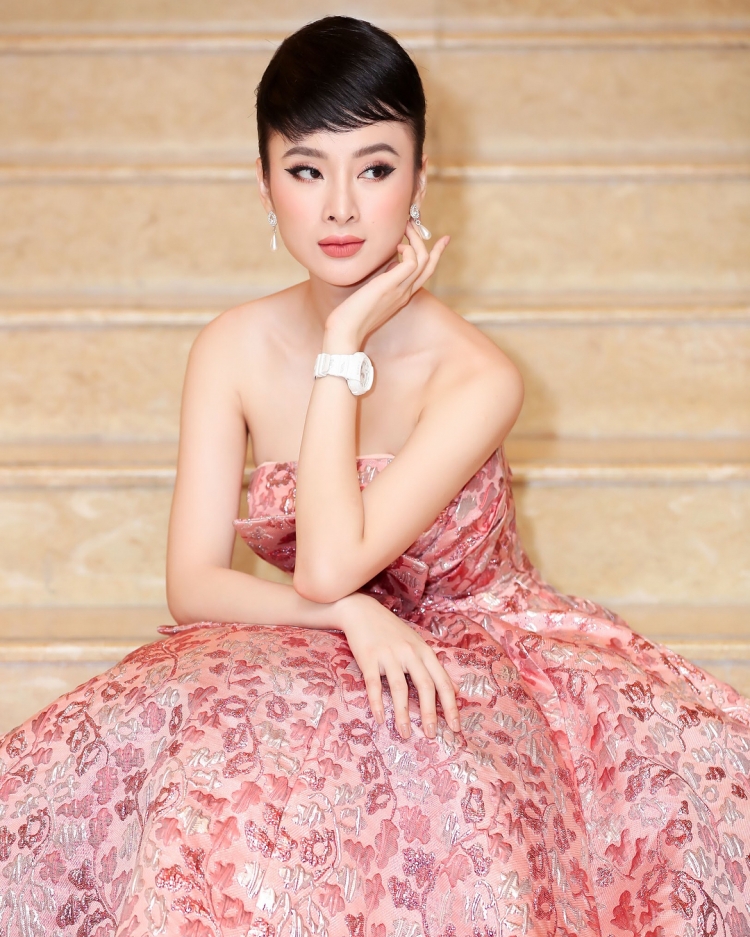 Angela Phương Trinh với tạo hình như minh tinh điện ảnh Audrey Hepburn hút mắt đối phương. Cô nàng mặc một chiếc đầm màu hồng san hô in họa tiết vô cùng nền nã, tôn lên bờ vai và Mừng SHBET phiên bản mới 2025 trắng ngần.  