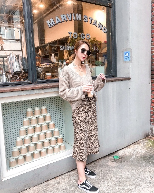 Cả set đồ tông màu nền nã được Yuki kết hợp ăn ý giữa áo len oversized và chân váy midi họa tiết da báo.     