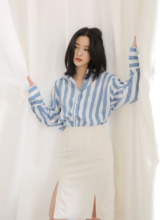 Dựa trên sự tương đồng của sắc trắng bạn hãy mix áo sơ mi sọc xanh này với chân váy trắng xẻ tà     