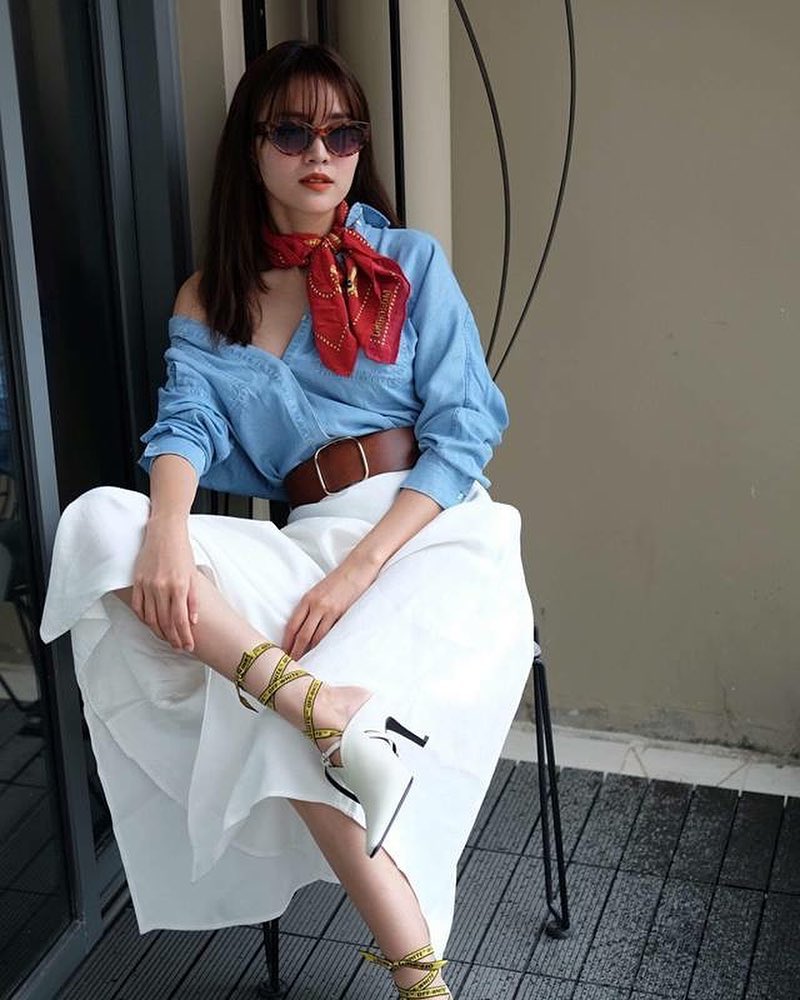 Ninh Dương Lan Ngọc diện áo sơ mi trễ vai cùng khăn tuban đỏ. Cô kết hợp đôi sandal trắng trông có vẻ điệu đà với dây giày Off-white tạo sự phá cách mới mẻ.  