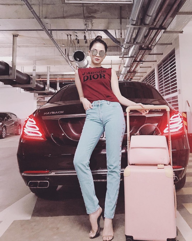 Áo Dior đỏ rực rỡ, quần jeans tông màu pastel ôm sát khoe trọn hình thể, nhưng điều mà khán giả nhớ đến lại nằm ở hai chiếc vali màu hồng rực rỡ, hết sức nổi bật mà Ngọc Trinh đang đặt cạnh bên.  