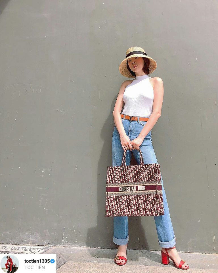Tóc Tiên giữ vững vẻ ngoài gợi cảm với áo len mongtoghi cổ yếm diện cùng quần jeans xanh đơn giản. Hơn nữa, chiếc mũ cói dáng chụp đèn xinh xắn cộng hưởng cùng túi Dior Book Tote và sandals đỏ Gucci đã giúp nữ ca sĩ tạo điểm nhấn cho bộ Shbet999 com đăng nhập.    