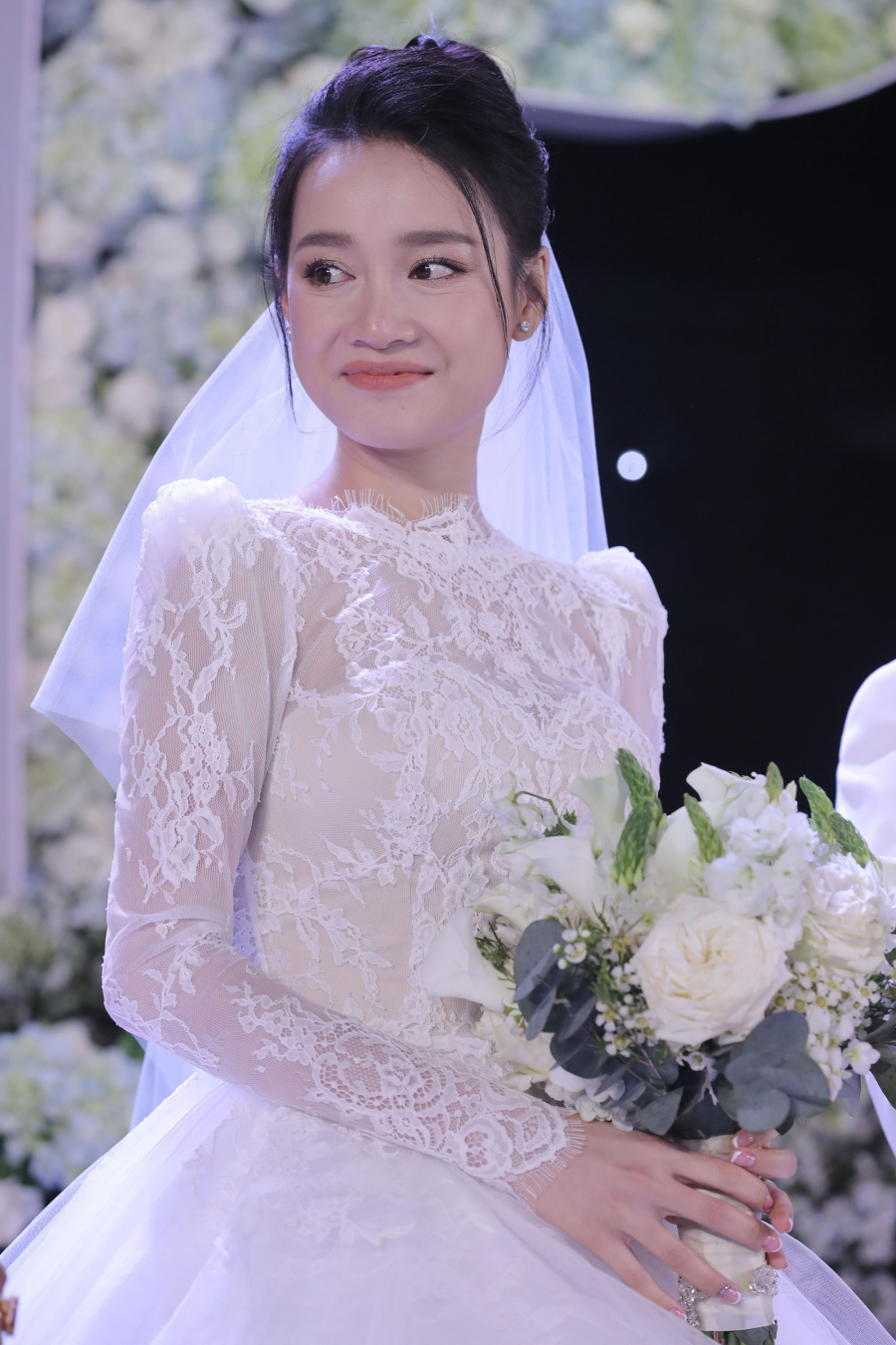Ở phần thân trên, nhà thiết kế sử dụng vải ren cotton nhập từ Pháp, cắt riêng từng mảnh ren, ráp và thêu thành hoa văn bằng tay. Phần ngực áo được dựng phom corset bằng vải màu da với rất nhiều gọng, giúp tôn vòng một của cô dâu. Đi kèm váy là khăn voan dài 4 m thướt tha.   