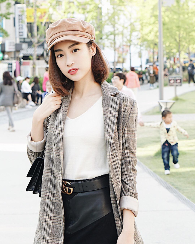 Cũng là blazer kẻ - item suốt từ năm ngoái đến năm nay vẫn sốt xình xịch, được HH Đỗ Mỹ Linh diện cho chuyến đi Hàn của mình. Nàng Hậu lên đồ đơn giản mà cực kỳ thời thượng với áo phông trắng trơn cùng blazer và chân váy da, không quên nhấn thêm mũ baker boy xuyệt tông với áo cùng túi xách và thắt lưng đồ hiệu đắt giá.    