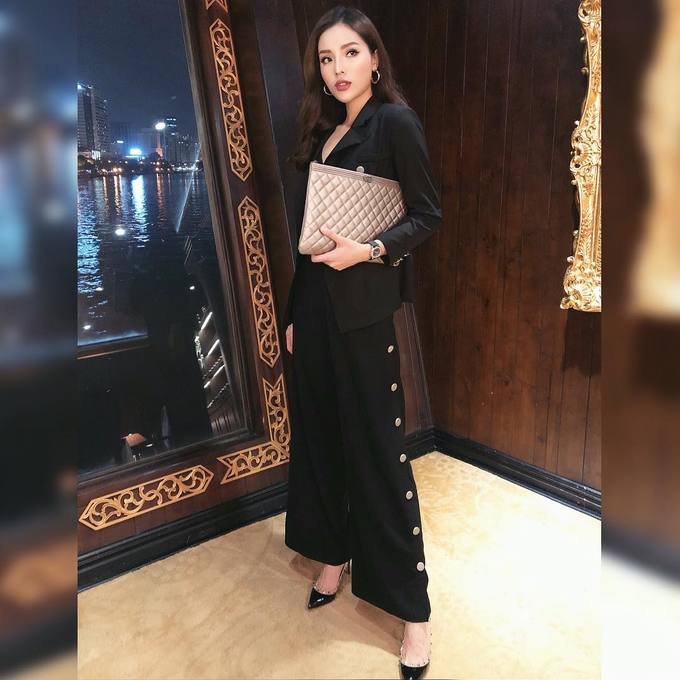 Hoa hậu Kỳ Duyên diện dáng quần suông rộng cùng giày cao gót và clutch to bản.     