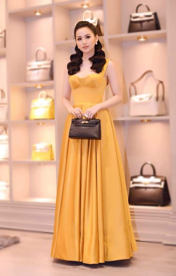 Tâm Tít khoe vẻ đẹp mặn mà đằm thắm nhưng không kém phần gợi cảm khi lựa chọn một mẫu đầm hai dây dáng xòe. Bộ cánh màu vàng nổi bật với chi tiết cúp ngực giúp người đẹp sinh năm 1989 khoe khéo được vòng 1 gợi cảm cùng bờ vai trần mảnh mai.    