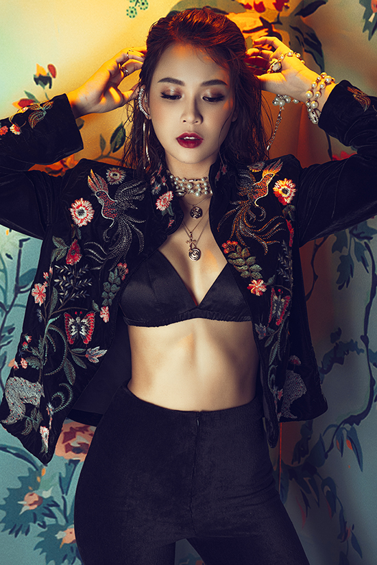 Áo khoác nhung thêu tạo nên điểm nhấn hút mắt cho set đồ all black gồm bra đen tiệp màu quần ống loe cổ điển.    