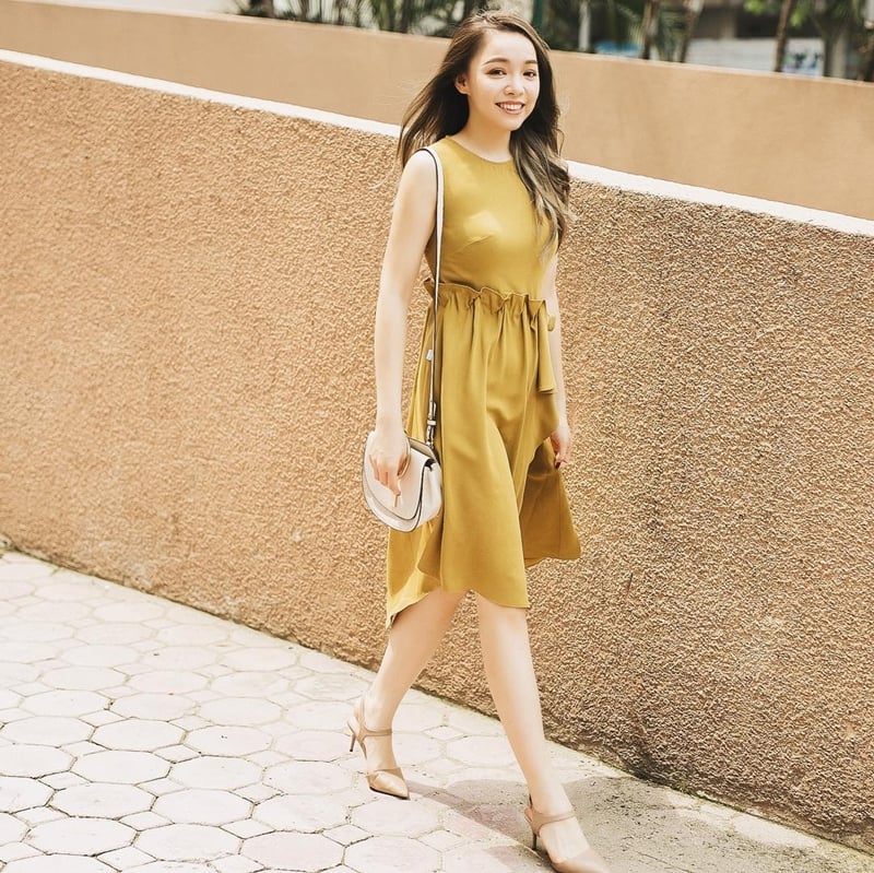 Bạn gái có thể tỏa sắc dịu dàng cùng bộ đầm sát nách chít eo, phủ sắc vàng nghiêng về gam màu camel nhã nhặn.    