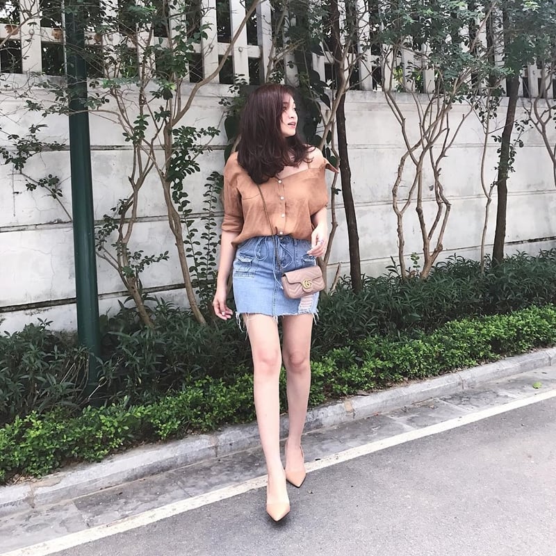 Các nàng có thể để lộ vai hờ hững với thiết kế sơ mi trễ nải màu camel, mix cùng chân váy denim rách phóng khoáng.