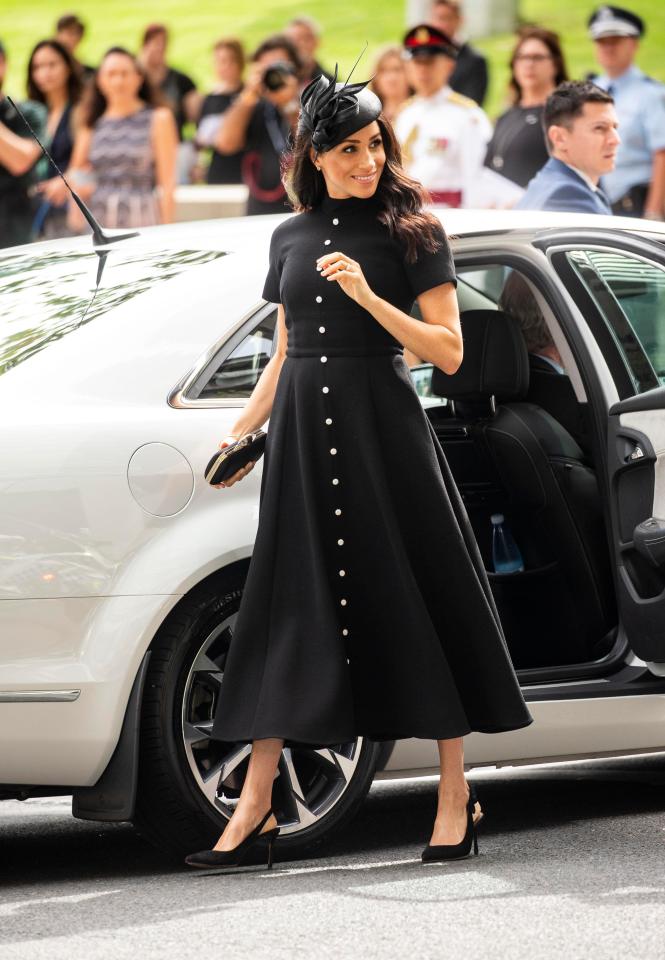Công nương Meghan diện váy đen giản dị với phần chân váy xuông và hàng cúc trắng làm điểm nhấn. Nổi bật là phụ kiện cài đầu thanh lịch “ton sur ton” với Shbet999 com đăng nhập  