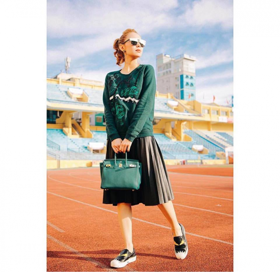 Minh Hằng vẫn chứng minh đẳng cấp street style không đối thủ. Xuống phố dịp 20/10 thời tiết se lạnh, nữ ca sĩ trẻ trung trong set đồ gồm chân váy xòe kết hợp áo nỉ xanh rêu và túi xách Hermes ton-sur-ton, giầy slip on.    