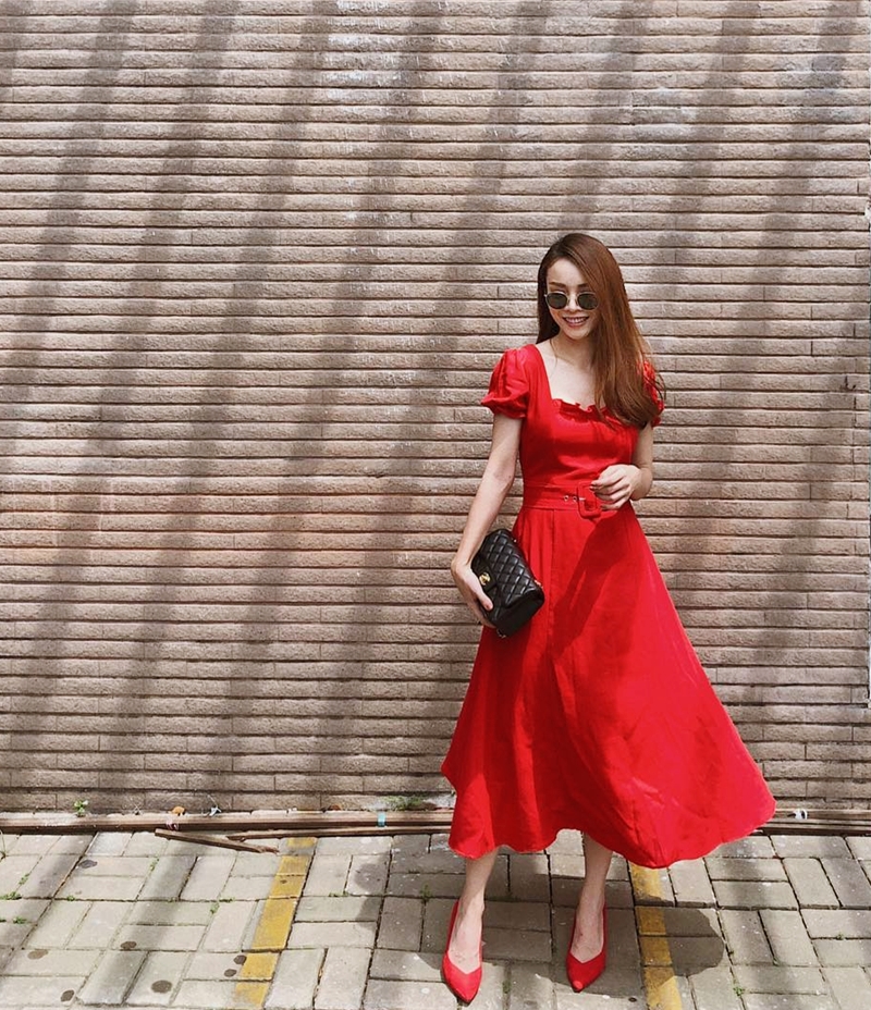 Đầm midi đỏ rực và giày cao gót đồng màu là cặp đôi lý tưởng khiến Yến Trang tỏa sắc kiêu kỳ trên phố. Sắc đỏ bắt mắt và tông màu đen của chiếc clutch cầm tay đem tới nét cổ điển song tràn ngập vẻ quyến rũ cho nữ ca sĩ.    