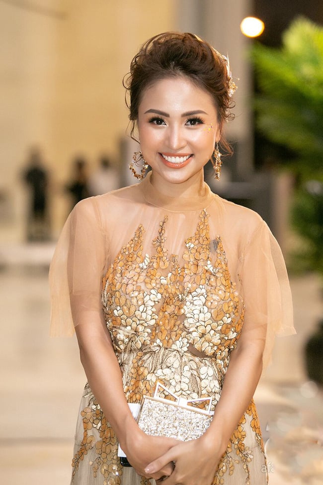 MC Vân Hugo nổi bật với chiếc váy cùng bộ phụ kiện tông vàng ánh kim.    