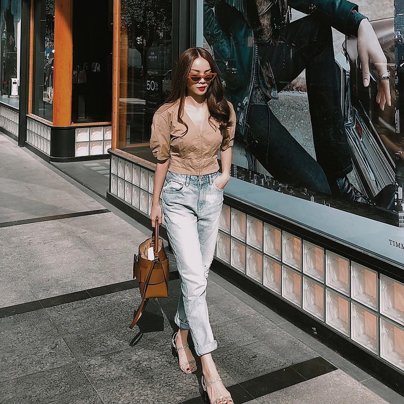 Yến Trang xuống phố ngày thu với áo sơ mi tay phồng “nhuộm” màu camel, kết hợp cùng quần jeans màu bạc và sandals cao gót. Nữ ca sĩ khéo léo điểm xuyết chiếc túi bucket, nhấn nhá vẻ năng động, trẻ trung.    