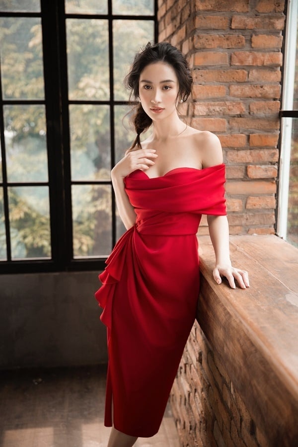 Cũng chọn một bộ cánh tông đỏ nhưng thiết kế của Jun Vũ lại có dáng ngắn trẻ trung. Bộ đầm trễ vai với chi tiết nhấn vào phần eo của NTK Lê Thanh Hoà giúp tôn lên vẻ đẹp mong manh ngọt ngào nhưng không kém phần gợi cảm quyến rũ của cô nàng này.    