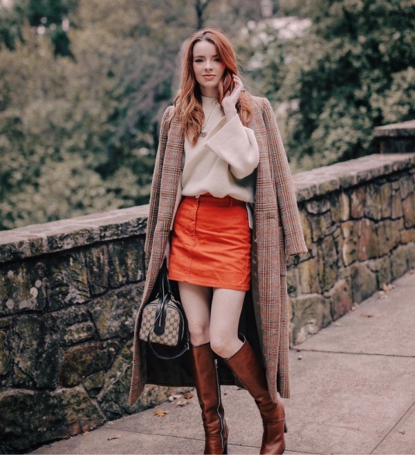 Jane Aldridge hết mực sang chảnh khi ghép cặp áo len sweater cùng chân váy ngắn và áo khoác trench coat dáng dài họa tiết kẻ. Kết hợp cùng các phụ kiện như boots đùi và túi xách của Gucci giúp fashionista phương Tây thêm phần sang chảnh.    