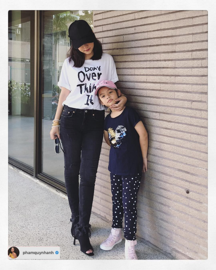 Nữ ca sĩ Phạm Quỳnh Anh kết hợp quần jeans tối màu với áo phông in slogan, thêm mũ lưỡi trai đen với bốt cao gót cùng màu.    