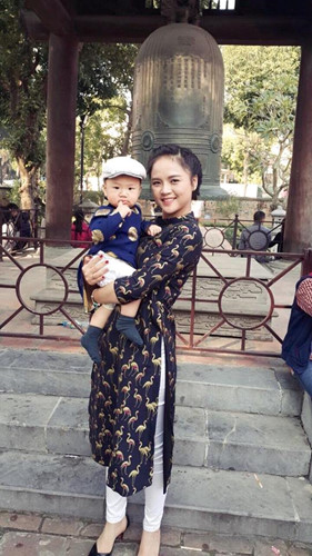 Trong một lần đi chơi cùng con trai, cô mặc áo dài cách tân tối màu phối với quần trắng.  