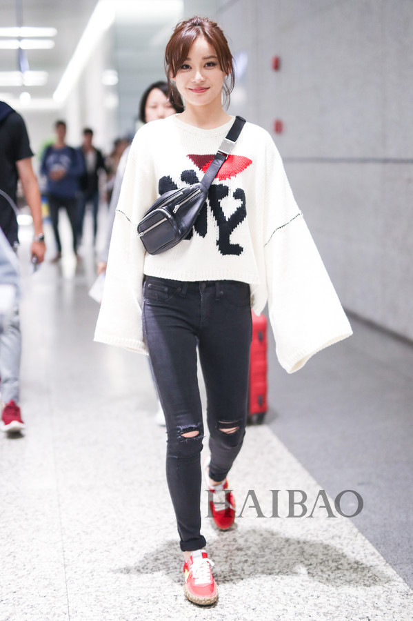Chiếc áo len trắng tay dáng dài rộng tạo điểm nhấn trẻ trung khi mix cùng jeans đen đơn giản của San San.
