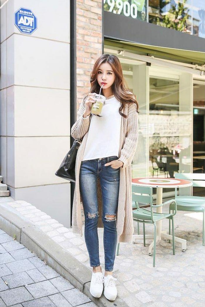 Set đồ gồm: Áo thun trơn, quần jeans rách gối, giày sneaker trắng cùng áo khoác len dáng dài cũng chính là một gợi ý tuyệt vời dành cho những ngày mùa đông chỉ vừa se lạnh.