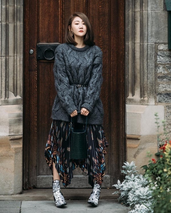 Với Regina, sự thanh lịch, phá cách nhưng không kém phần hợp gu luôn được cô đề cao. Lựa chọn trưng diện áo len vặn thừng mix với chân váy xếp li in họa tiết, cô sử dụng thêm thắt lưng da bản nhỏ để tạo vẻ chỉn chu, gọn gàng cho diện mạo.    