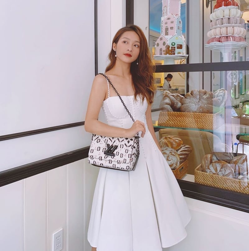Khả Ngân hoá nàng tiểu thư đài các với chiếc đầm trắng, có đường cắt cúp tinh tế. Chiếc túi Twist của Louis Vuitton là “gia vị” hoàn thiện phong cách nữ tính, giúp bộ cánh của mỹ nhân “Hậu duệ mặt trời” thêm đắt giá.    