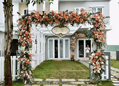 Căn nhà nằm trong một khu biệt thự sang trọng với tông màu xám và trắng chủ đạo. Phía trước sân nhà có trồng thảm cỏ xanh mát mắt. Lối đi vào được ốp đá trắng sạch sẽ    