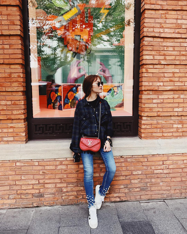 Hot mom Thanh Huyền chơi luôn set layer sơmi kẻ cùng áo phông, thú vị nhất là chiếc quần jeans đính kết mà mẹ 2 con mặc. Cứ nghĩ đây là mốt dành cho các teen girl ai ngờ mẹ 2 con mặc cũng chất hết phần người khác.    