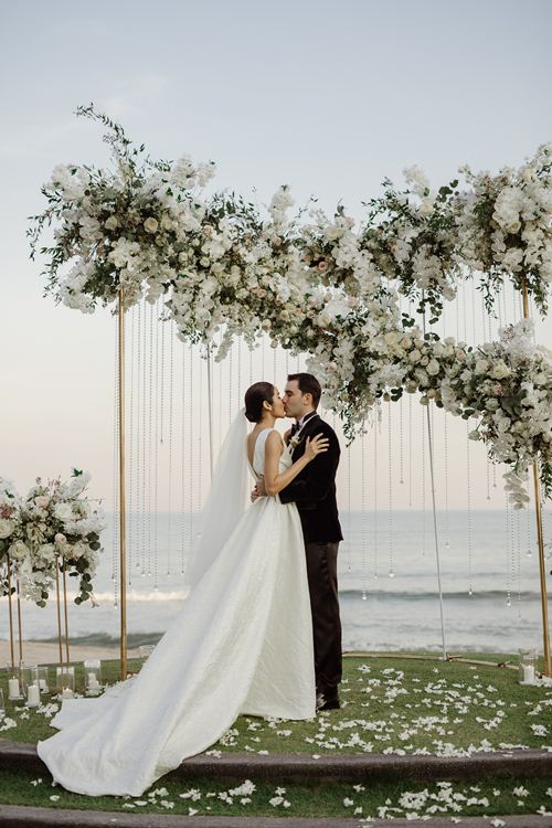 Trong ngày cưới, Farung Yuthithum chọn diện thiết kế của Đỗ Mạnh Cường. Người đẹp 31 tuổi diện chiếc váy xoè dài với phần ngực xẻ chừng mực, có những nếp gấp tạo phom ở hai bên.    