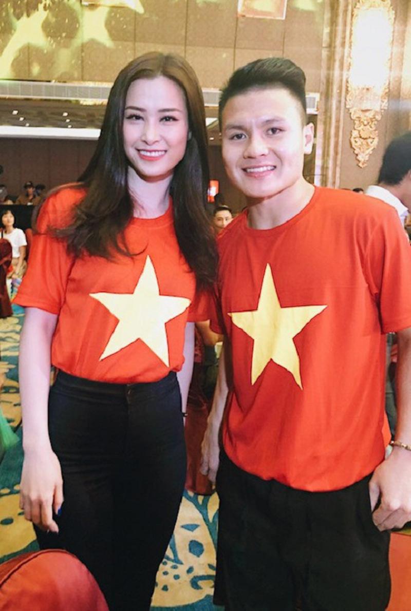Đông Nhi giản dị mà vẫn xinh đẹp khi diện áo cờ đỏ sao vàng cùng với cầu thủ Quang Hải.     