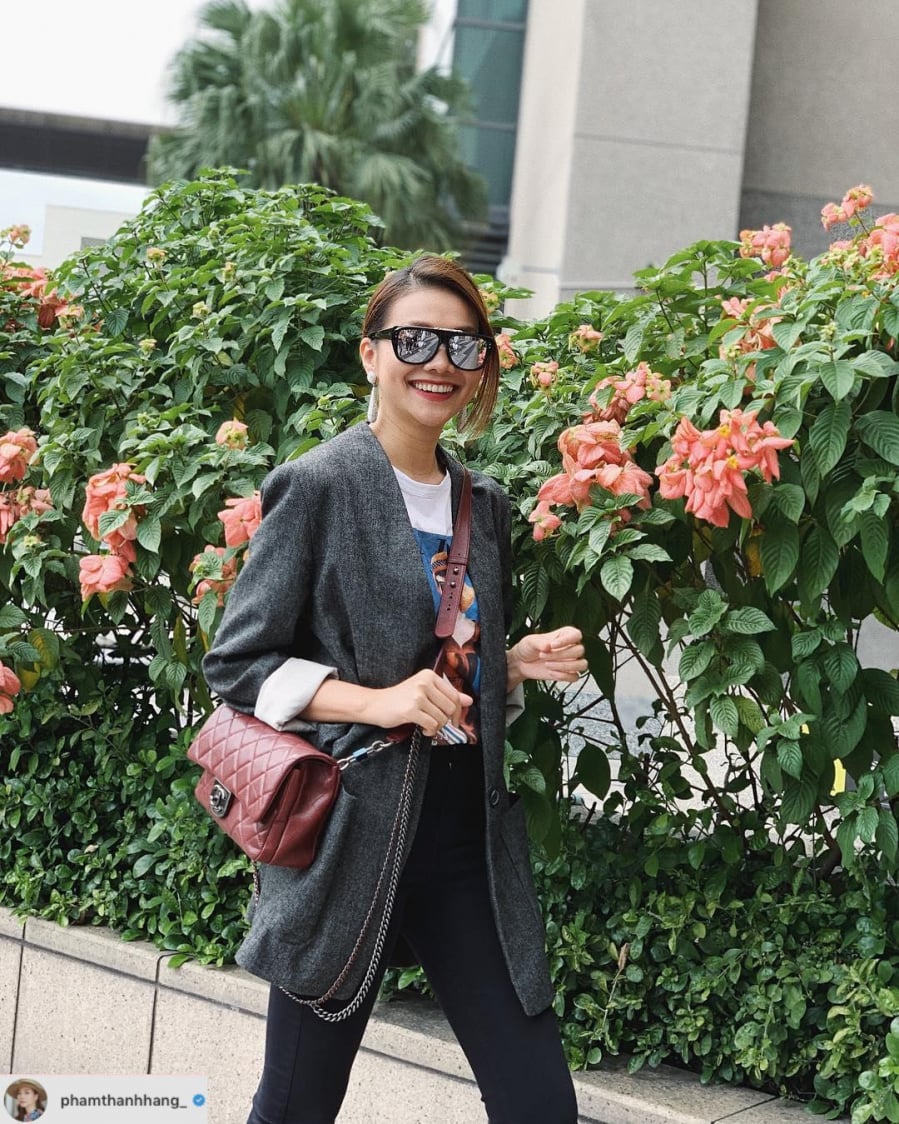 Thanh Hằng lựa chọn áo khoác blazer kết hợp cùng áo phông và quần jeans tối màu. Phụ kiện không thể thiếu là kính mắt to bản và một chiếc túi xách tạo điểm nhấn.