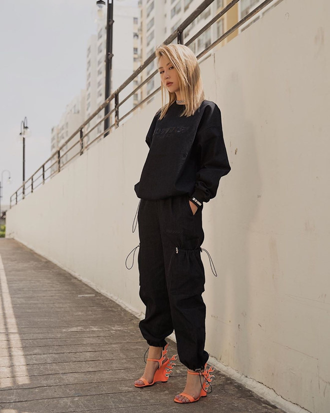 Quỳnh Anh Shyn cá tính với set đồ đen, mang hơi hướm hip hop. Đôi giày cao gót hình tia lửa, tông cam neon của Prada chính là phụ kiện khiến tổng thể Shbet999 com đăng nhập càng thêm ấn tượng trên phố.