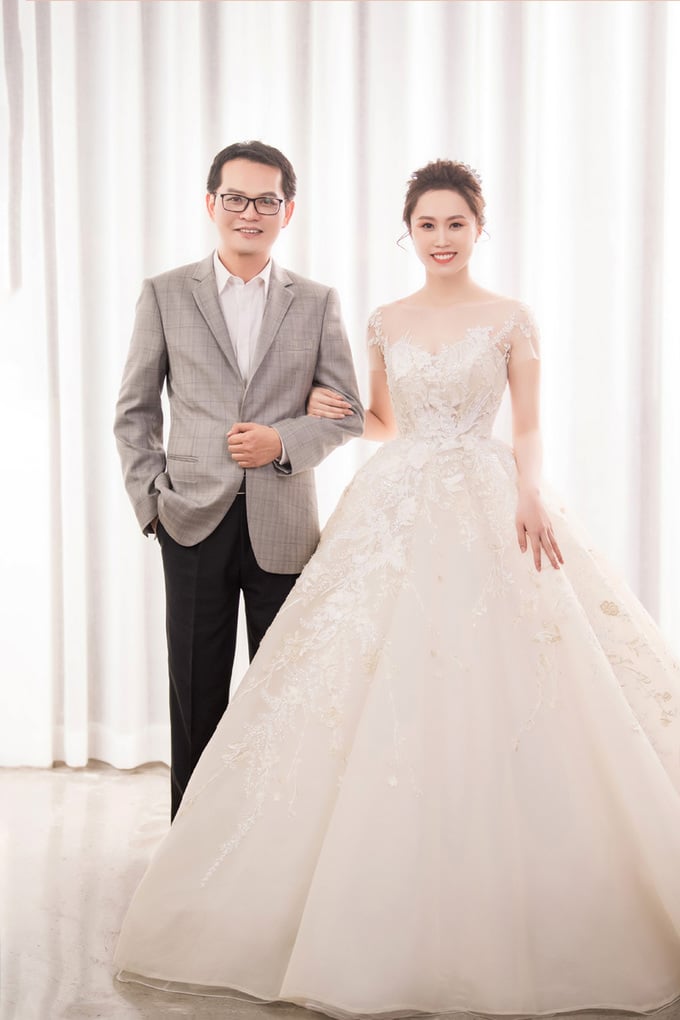 Cô dâu diện thêm váy bồng công chúa màu kem ánh vàng kim với toàn bộ chi tiết thêu 3D từ chỉ tơ vàng. NTK dựng gọng chiết eo mang phom dáng corset lót trong giúp nhấn vòng eo con kiến của tân nương.     