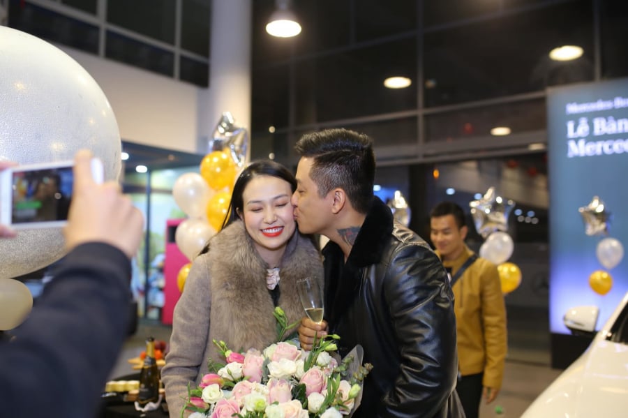 Hai vợ chồng dành cho nhau nụ hôn ngọt ngào trong buổi nhận xe.   